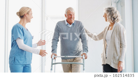 With support, progress is always possible. a senior man using a walker with the assistance of his wife and young nurse. 102514835
