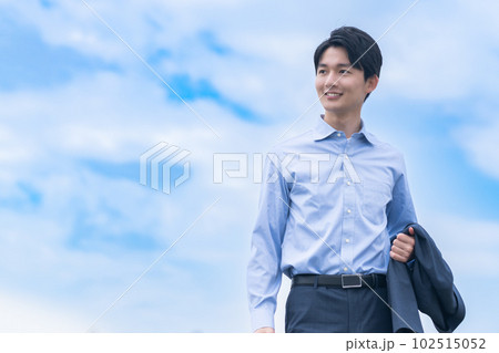 オフジャケットで爽やかに歩く若いビジネスマン 102515052