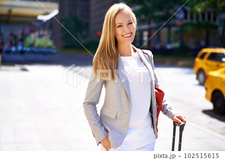 Shes going places. A beautiful woman walking around a city with her luggage. Shes going places. A beautiful woman walking around a city with her luggage. 102515615