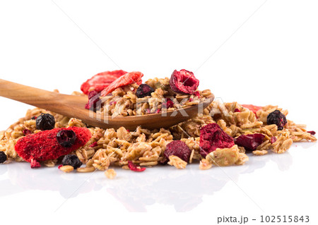 Muesli oat cereals close up background with dry fruits in wooden spoon Muesli oat cereals close up background with dry fruits in wooden spoon 102515843