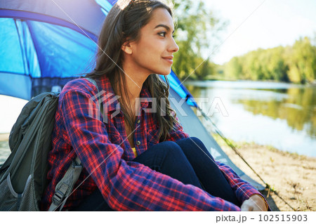 Shes getting away from everything. an attractive young woman sitting at her campsite. Shes getting away from everything. an attractive young woman sitting at her campsite. 102515903