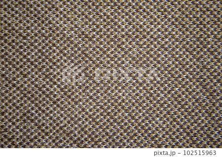 Knitted pattern of brown, white and orange yarns. Brown knitted fabric. Knitted texture. Knitted pattern of brown, white and orange yarns. Brown knitted fabric. Knitted texture. 102515963