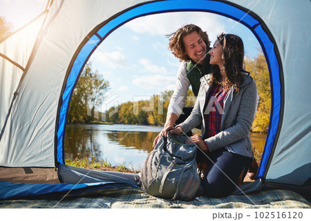 Its just the two us out here, together. Full length shot of an affectionate young couple at their campsite. 102516120