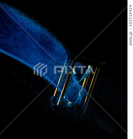 Hourglass fly float in mid air. Life is blue sand around hourglass to add more limited time. Deadline extended time management hope concept hour glass. Black background shadow life clock passing by Hourglass fly float in mid air. Life is blue sand around hourglass to add more limited time. Deadline extended time management hope concept hour glass. Black background shadow life clock passing by 102516424