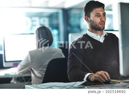 Focused on succeeding. a young businessman working on his computer at his desk. Focused on succeeding. a young businessman working on his computer at his desk. 102516692