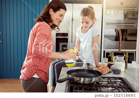 Shes the best assistant ever. a mother baking with her daughter in the kitchen. Shes the best assistant ever. a mother baking with her daughter in the kitchen. 102516693
