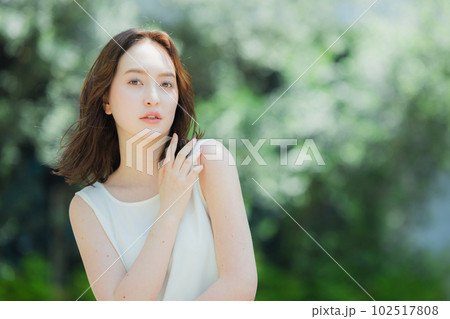 屋外を歩くノースリーブの女性 102517808