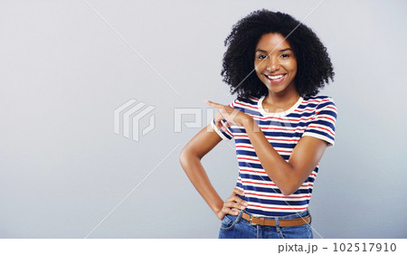 Have you seen this. Studio shot of an attractive young woman pointing at copy space against a grey background. Have you seen this. Studio shot of an attractive young woman pointing at copy space against a grey background. 102517910