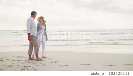 The course of true love is full of happiness. Full length shot of an affectionate senior couple having a laugh together while taking a walk along the beach. 102520111