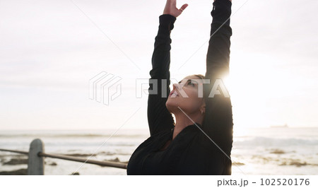 Let go of all the negativity surrounding you. a woman practising yoga on the promenade. 102520176
