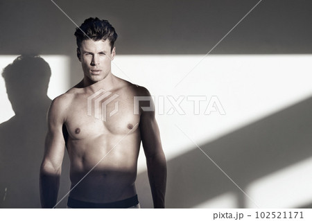 Fitness, portrait of young muscular man and mockup in a studio background. Goal motivation or positive mindset, shirtless bodybuilder and male sports athlete promote training or workout against wall Fitness, portrait of young muscular man and mockup in a studio background. Goal motivation or positive mindset, shirtless bodybuilder and male sports athlete promote training or workout against wall 102521171