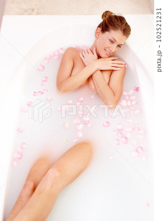 Woman, rose and milk bath with flower petals and luxury bathroom treatment feeling calm. Body care, cleaning and female person relax in a home with floral aromatherapy and natural wellness wash Woman, rose and milk bath with flower petals and luxury bathroom treatment feeling calm. Body care, cleaning and female person relax in a home with floral aromatherapy and natural wellness wash 102521231
