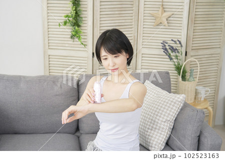 自宅で腕のセルフ脱毛をする女性 自宅で腕のセルフ脱毛をする女性 102523163