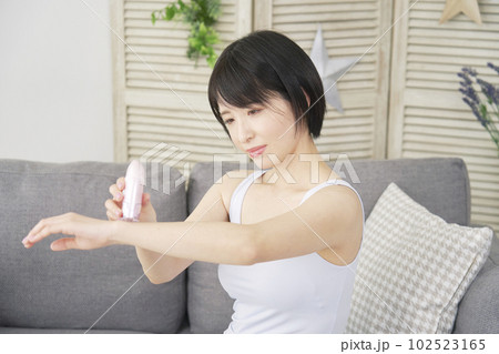 自宅で腕のセルフ脱毛をする女性 102523165