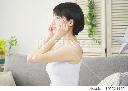 自宅で顎ののマッサージをする女性 自宅で顎ののマッサージをする女性 102523185