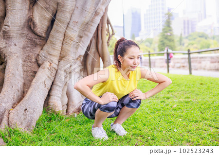 公園で屈伸運動をする女性 102523243