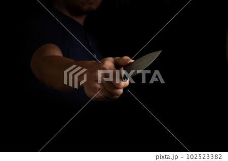 Adult Man Holding Sharp Knife in the Shadow. Concept Picture of Murderer, Killer, Assasin, Robber or Theft Adult Man Holding Sharp Knife in the Shadow. Concept Picture of Murderer, Killer, Assasin, Robber or Theft 102523382