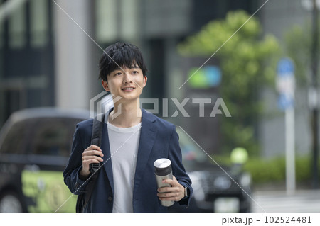 マイボトルを持って街を歩く20代の男性 102524481