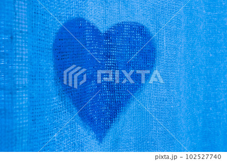 A cold heart is a sign and symbol of cooled, non-reciprocal love heartache on a blue background A cold heart is a sign and symbol of cooled, non-reciprocal love heartache on a blue background 102527740