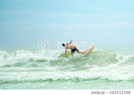professional surfer riding waves in Thailand, men catching waves in ocean,beach swimming activity on summer vacation professional surfer riding waves in Thailand, men catching waves in ocean,beach swimming activity on summer vacation 102531386