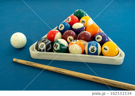 Billiard balls in triangle rack with cues on table at snooker club. Billiard balls in triangle rack with cues on table at snooker club. 102531534