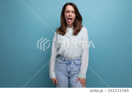 funny young brunette woman in shirt with grimace on studio background funny young brunette woman in shirt with grimace on studio background 102531560