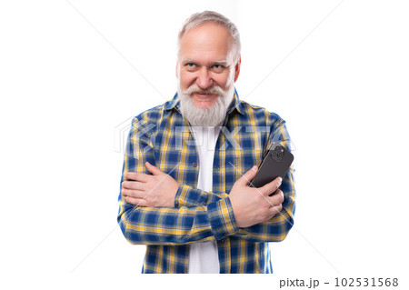 handsome 50s mid aged gray-haired man with a beard in a shirt with a smartphone on a white handsome 50s mid aged gray-haired man with a beard in a shirt with a smartphone on a white 102531568