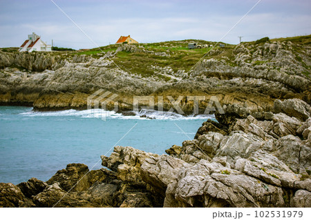 Beaches of a Costa de Cantabria, North of Spain, Santander Picturesque beach, rocks stones in waters of Atlantic Ocean. Travel destination, tourism in summer. Houses on a rocky bay in gloomy day. 102531979