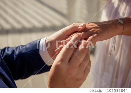 Newlyweds exchange rings, groom puts the ring on the bride's hand. 102532844