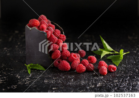 Fresh sweet raspberry in black cup 102537163