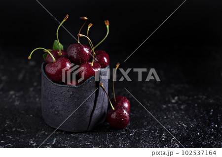 Fresh sweet cherries in black cup Fresh sweet cherries in black cup 102537164