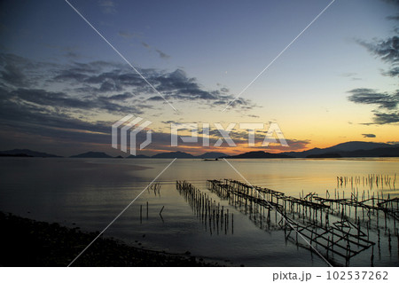 牡蠣棚並ぶ瀬戸内の秋の夕焼けとホボロ島 102537262