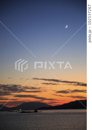 瀬戸内の夕焼け空に輝く三日月 102537267