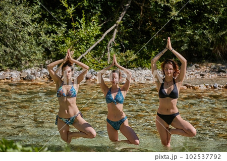 Girls having yoga session in flowing river Girls having yoga session in flowing river 102537792