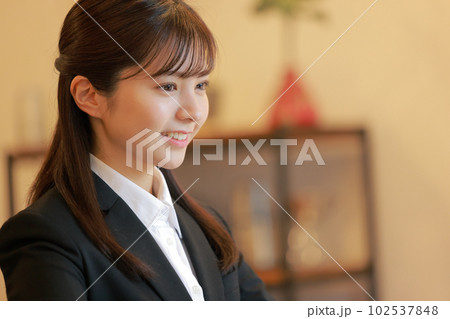 にこやかにデスクワークする女性_クローズアップ1 102537848