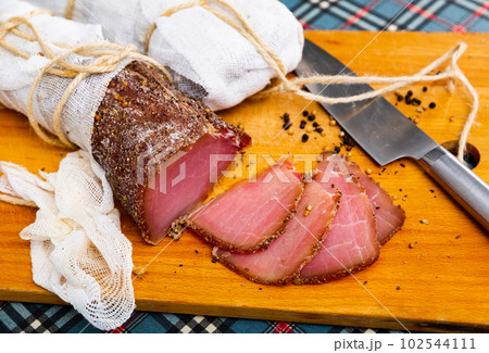 Cured pork meat sliced on wooden board 102544111