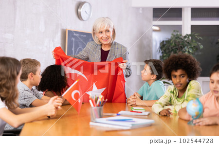Smiling mature female teacher tells pupils the history of Turkey 102544728
