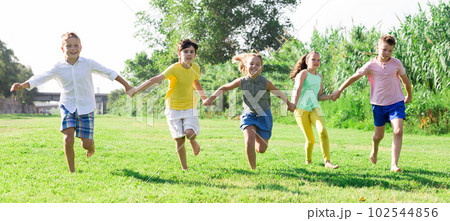Barefoot kids running on green grass 102544856