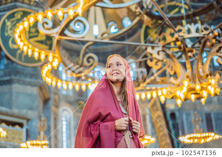 Woman tourist enjoying Hagia Sofia, Ayasofya interior in Istanbul, Turkey, Byzantine architecture, city landmark and architectural world wonder. Turkiye 102547136