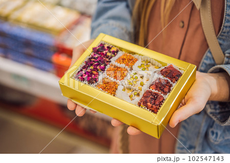 Traditional oriental sweet pastry cookies, nuts, dried fruits, pastilles, marmalade, Turkish desert with sugar, honey and pistachio, in display at a street food market 102547143