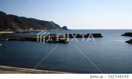 笹川流れの入り口の桑川漁港から見える桑川集落と日本海と山と岬 笹川流れの入り口の桑川漁港から見える桑川集落と日本海と山と岬 102548349