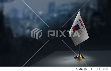 A small Mayotte flag on an abstract blurry background 102548506