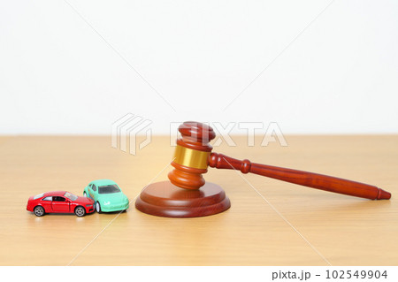 Car Law, Insurance, auto Tax, Auction and Bidding concepts. crashed small toy car models with Judges gavel on desk in courthouse. 102549904
