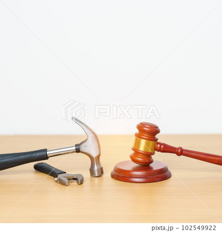 Labor law and Worker concepts. Construction hammer with gavel justice hammer on desk in courthouse. Labor law and Worker concepts. Construction hammer with gavel justice hammer on desk in courthouse. 102549922