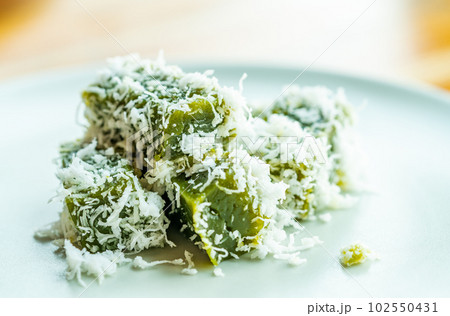 Close up a traditional Thai healthy dessert menu called Kanom Piak Poon or sticky and soft dough with the taste of Pandanus, combine with fresh coconut meat shred, natural light image. 102550431