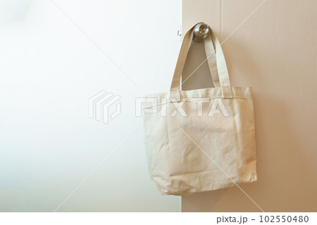 Eco friendly bag hanging on the door. Canvas Shopping tote bag. Zero waste, Reusable, Say No Plastic, Sustainability, World Environment day and Earth day concept Eco friendly bag hanging on the door. Canvas Shopping tote bag. Zero waste, Reusable, Say No Plastic, Sustainability, World Environment day and Earth day concept 102550480