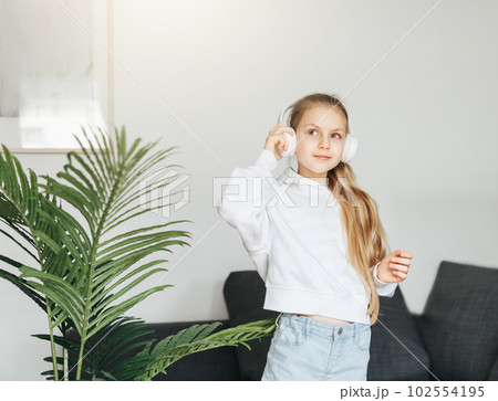 Cute little girl listening to music in headphones 102554195