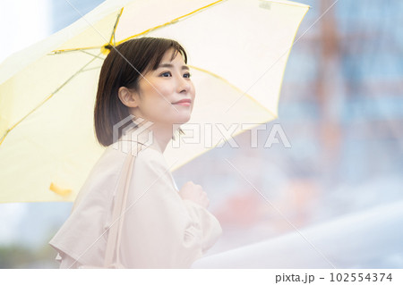 雨の中で待つ女性　傘をさす若い女性 102554374