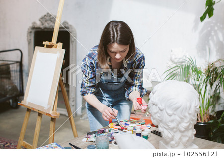 Woman painting a picture at the easel. Woman painting a picture at the easel. 102556121
