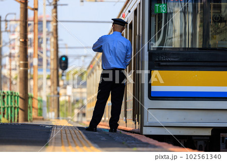 駅のプラットフォームの上で発車時刻を確かめる男性の車掌 駅のプラットフォームの上で発車時刻を確かめる男性の車掌 102561340